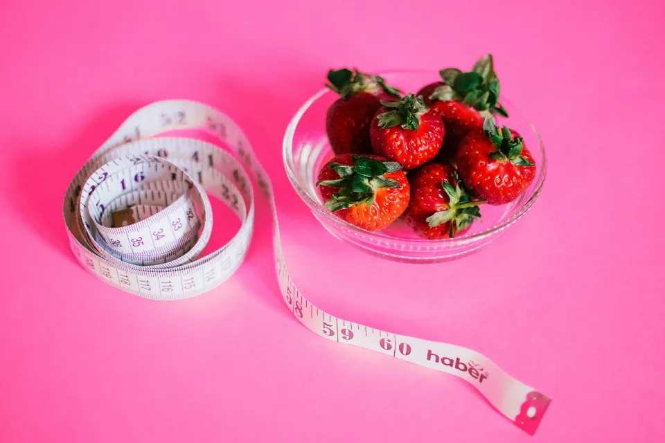 Flexible tape measure next to a bowl of strawberries